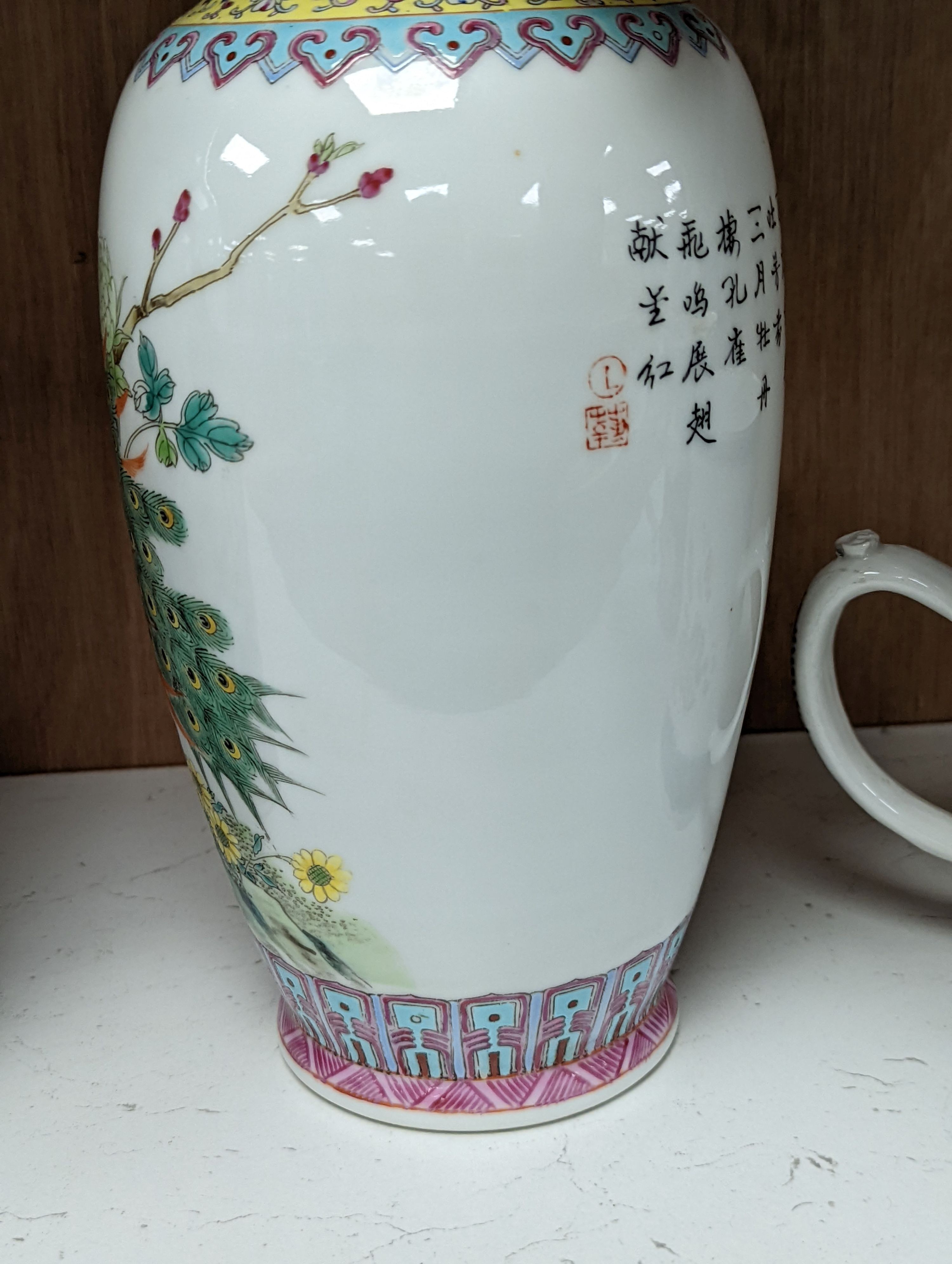 A pair of Chinese famille rose vases decorated with peacocks, 31cm